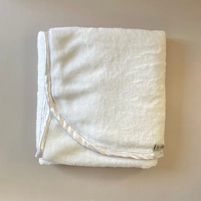 White fleece cuddle blanket with white satin trim.